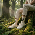 Person sitting on a tree stump in a forest wearing white sneakers and socks with text.